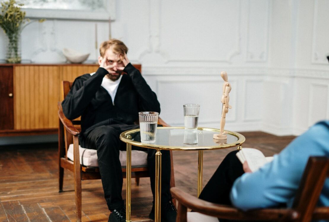 Man in Black Suit Sitting on Chair